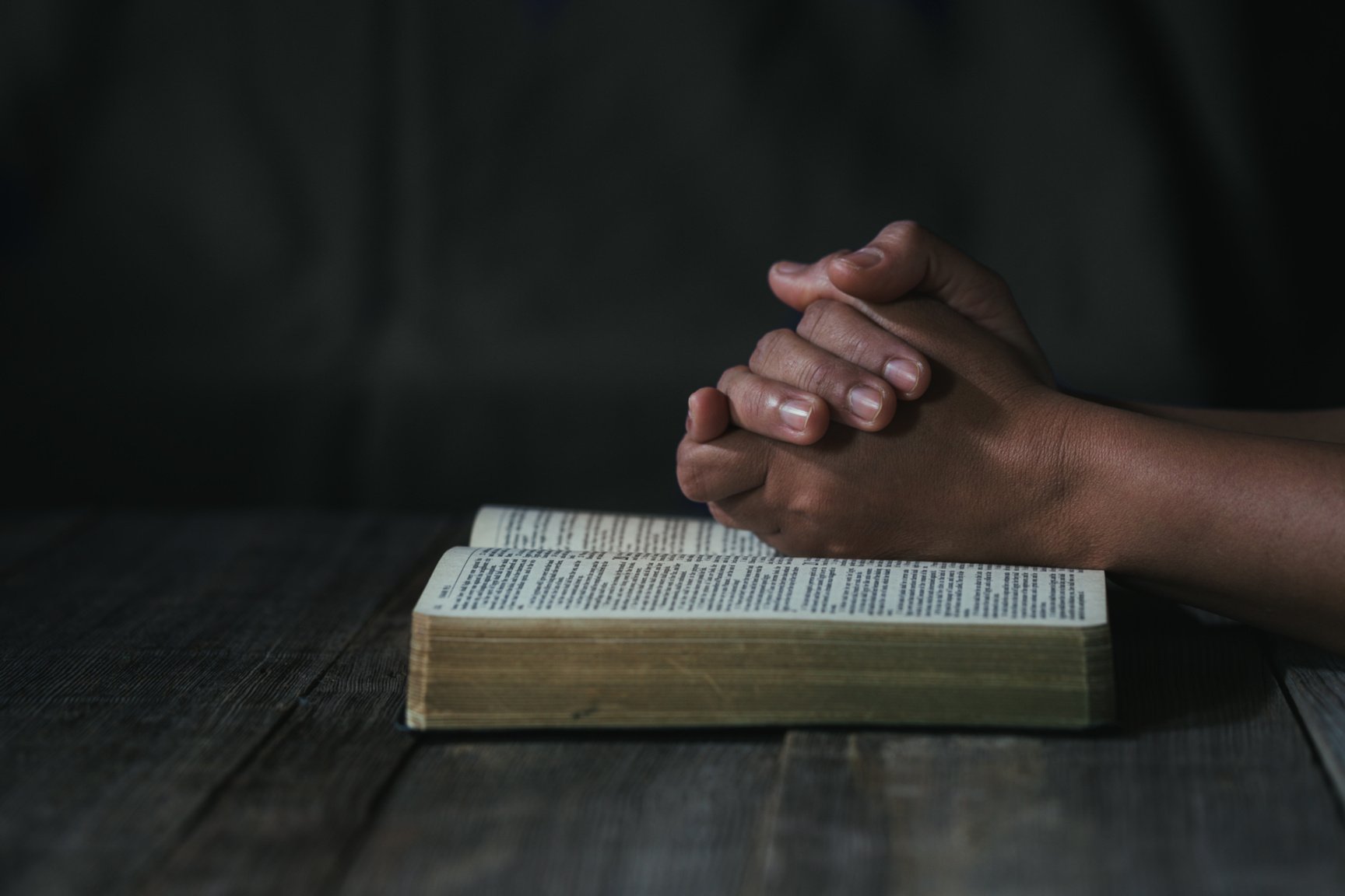 Hands Folded in Prayer on a Holy Bible 